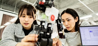 Two young tech professionals working with robotics