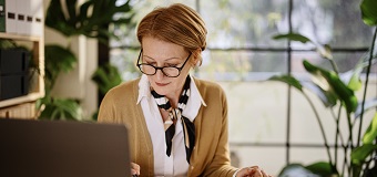 Woman works at her laptop in a bright home office
