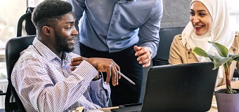 Workers sat in front of a laptop